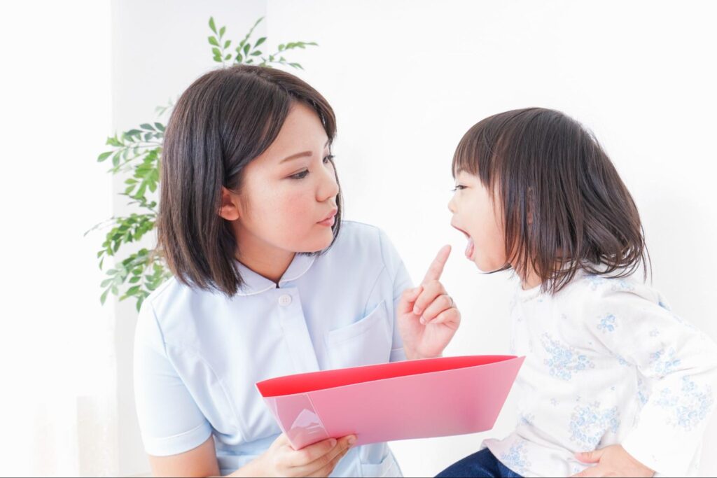口の中のチェックを受ける子ども