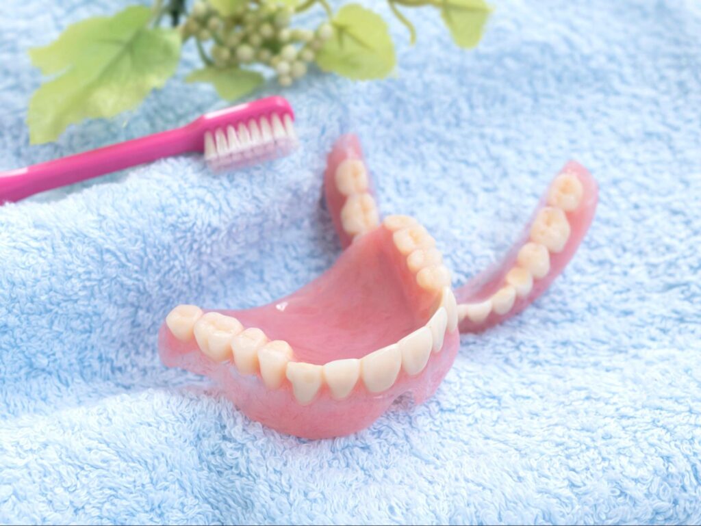 タオルに乗った歯ブラシと入れ歯