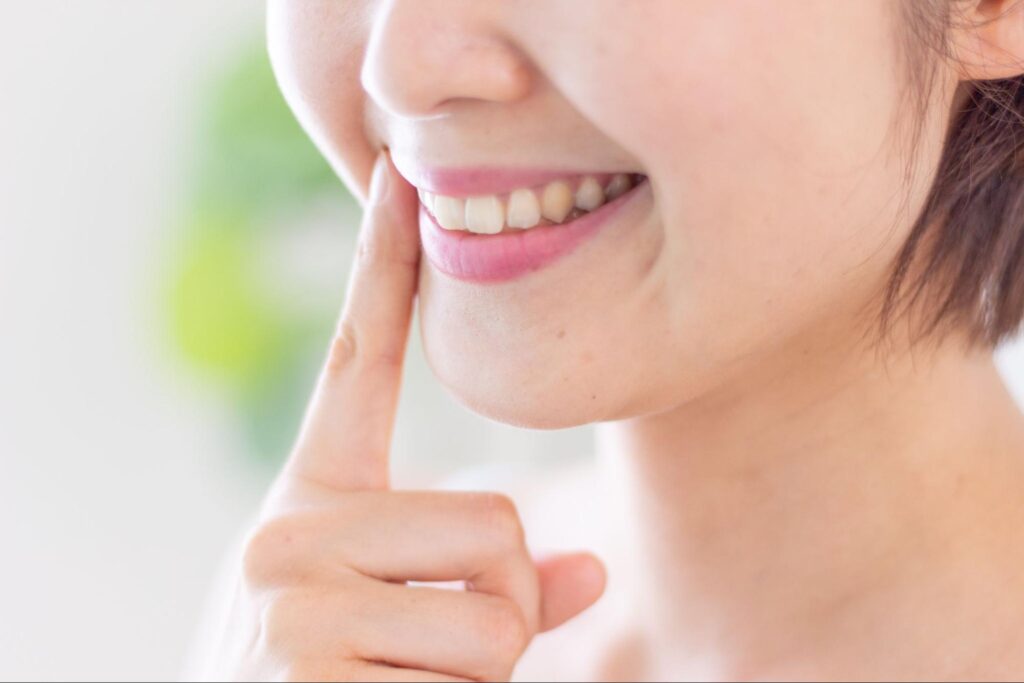 口元を指差す女性