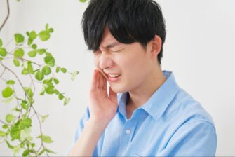 歯の痛みに顔をしかめる男性