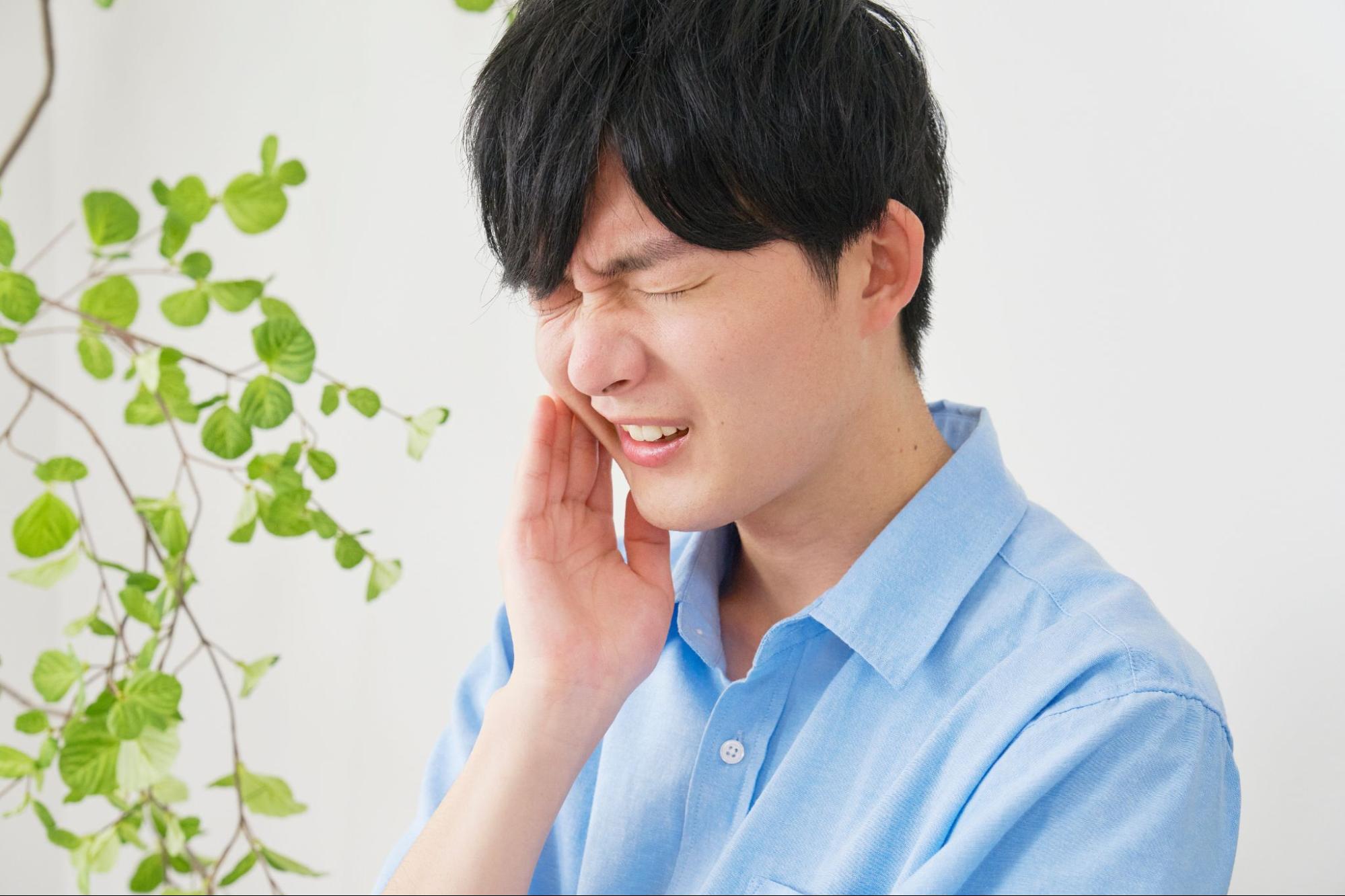 歯の痛みに顔をしかめる男性