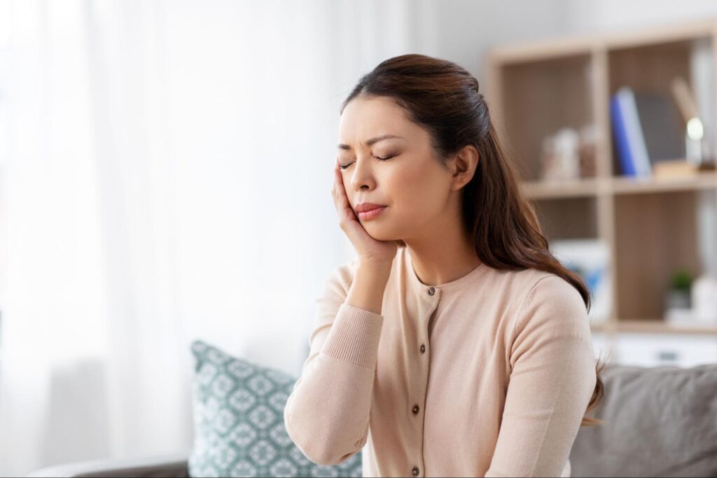頬を押さえる女性