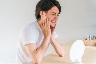 強い歯の痛みを感じる男性