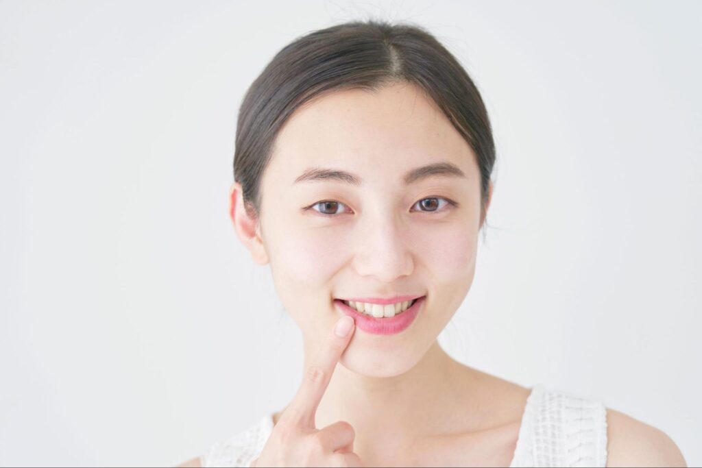 歯を指差す若い女性