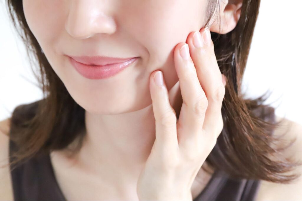 頬を押さえる女性
