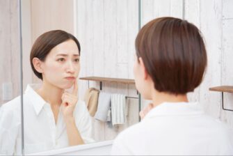 困った顔で鏡を見る女性