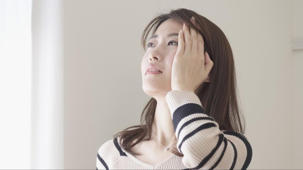 頭を押さえる女性