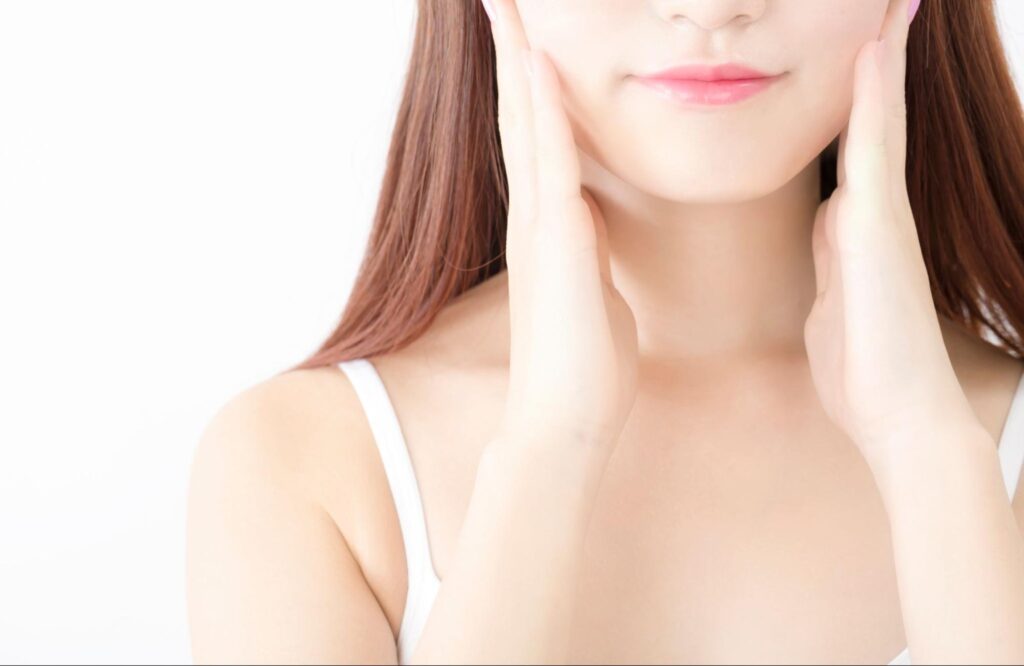 顎を両手で押さえる女性