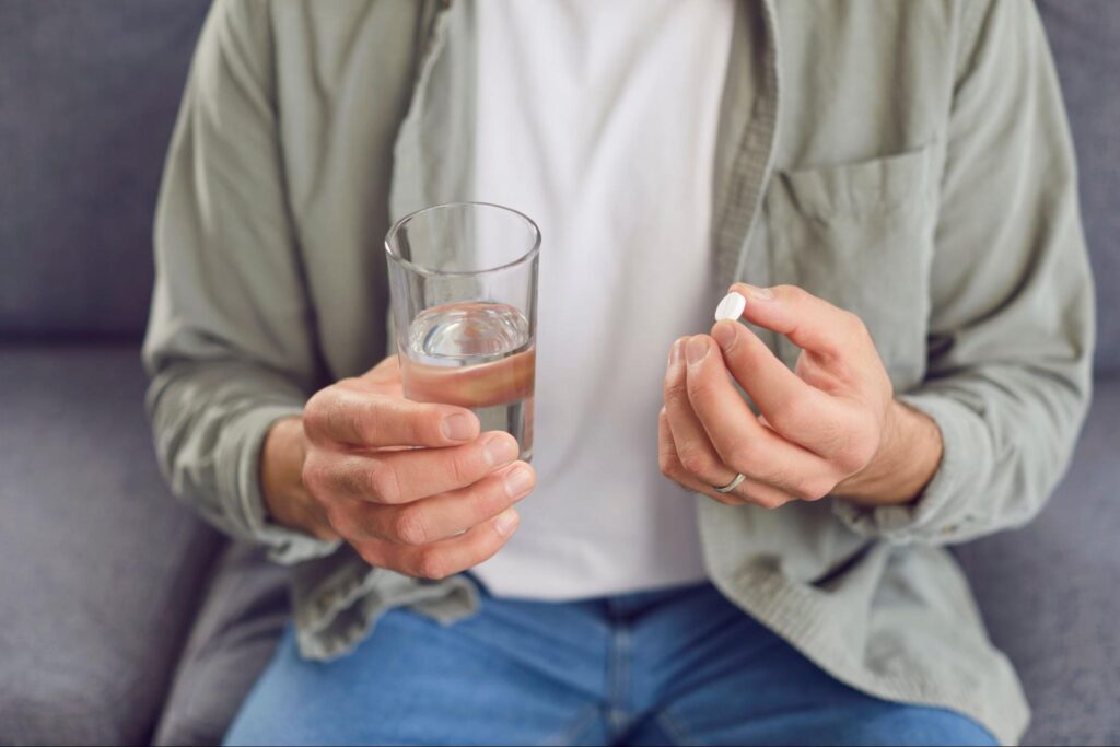 生えかけの親知らずが痛み鎮痛剤を飲もうとしている人
