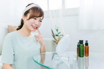 鏡で痛む歯を見ている女性