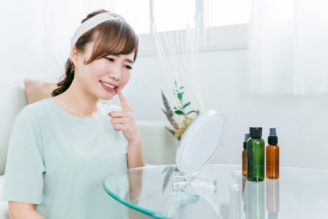 鏡で痛む歯を見ている女性