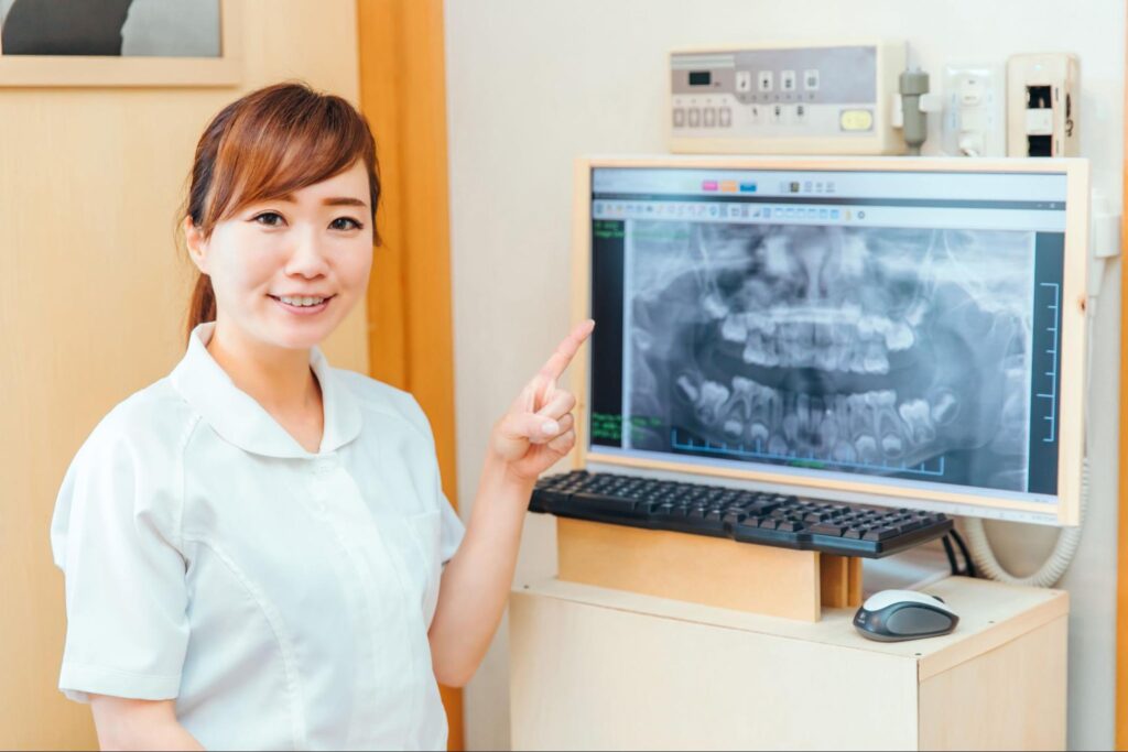 レントゲンを指差す歯科医療従事者