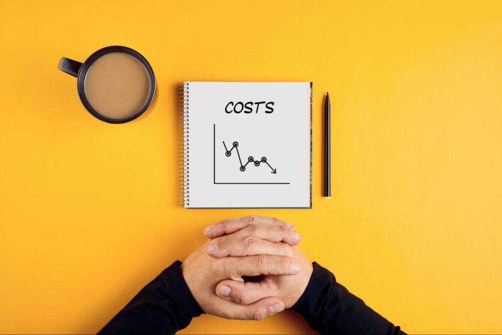COSTSと書かれた髪と腕を組む人の手元