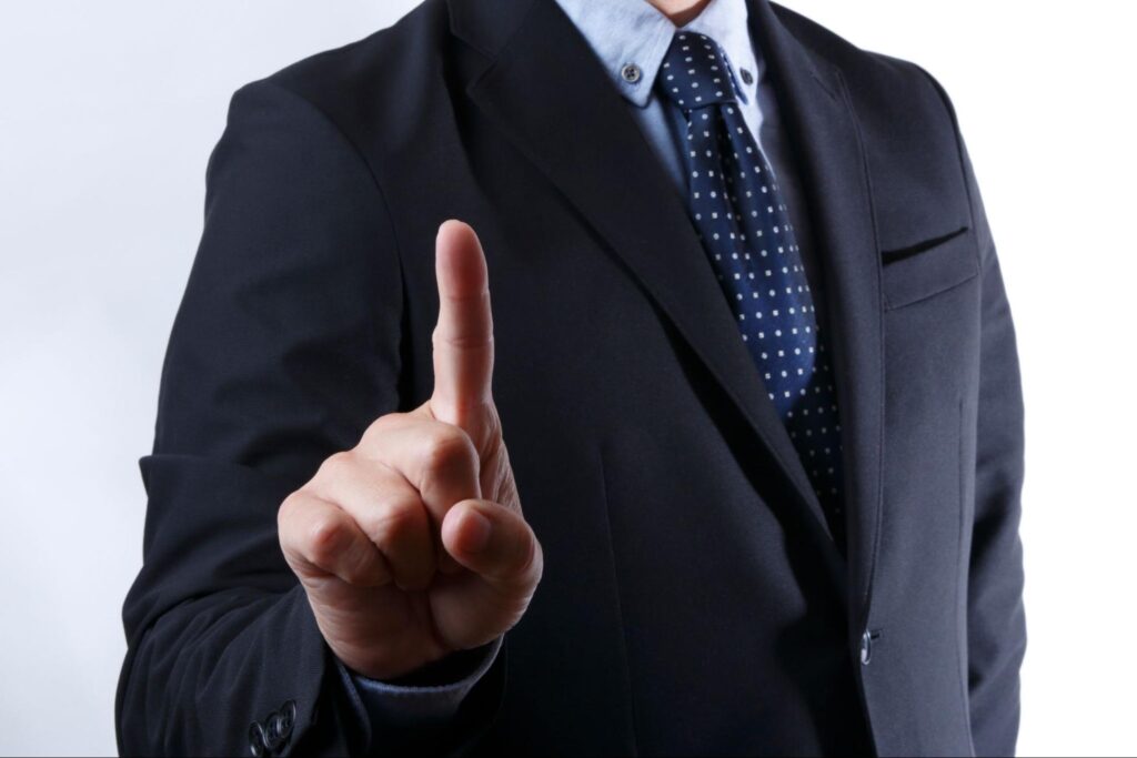 人指し指を立てる男性