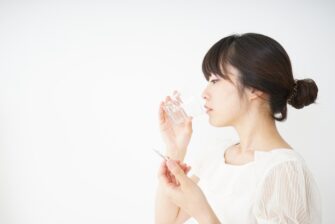 親知らずの痛み止めを飲む女性
