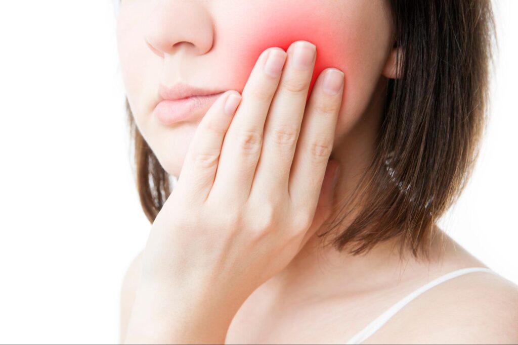 親知らずの痛みがピークで頬を抑える女性
