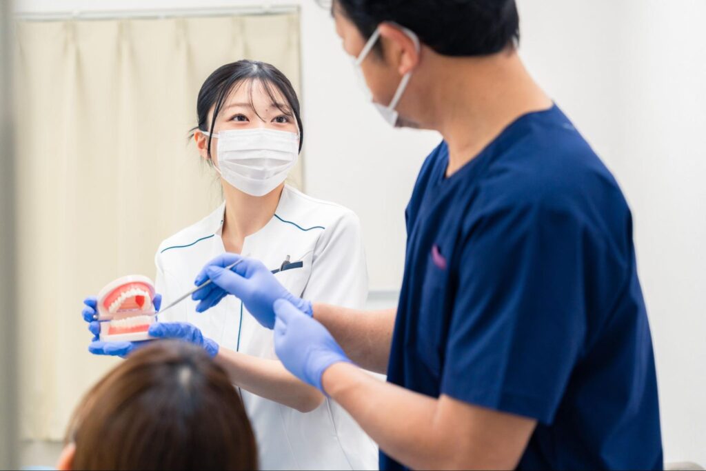 患者さんに親知らずについて説明している医師と歯科衛生士