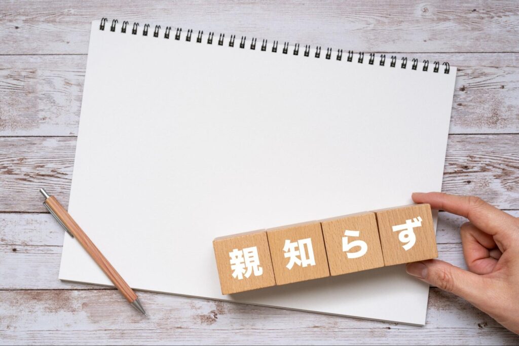 親知らずと書かれた木製ブロックとスケッチブック