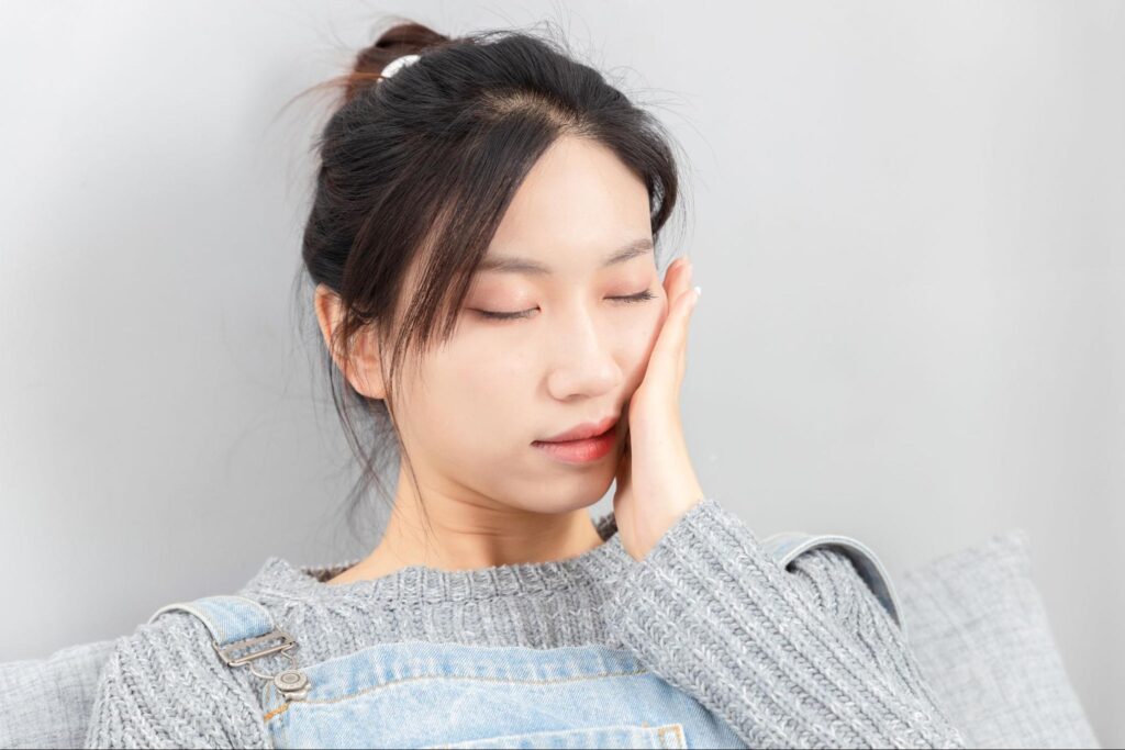 親知らずの痛みがピークで頬を抑える女性