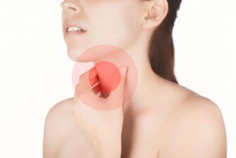 親知らずによる喉の痛みを感じ、喉を押さえる女性