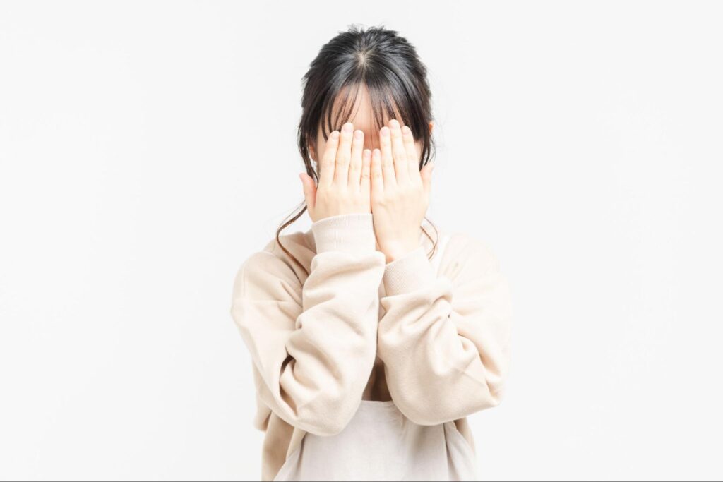 顔を隠す20代女性